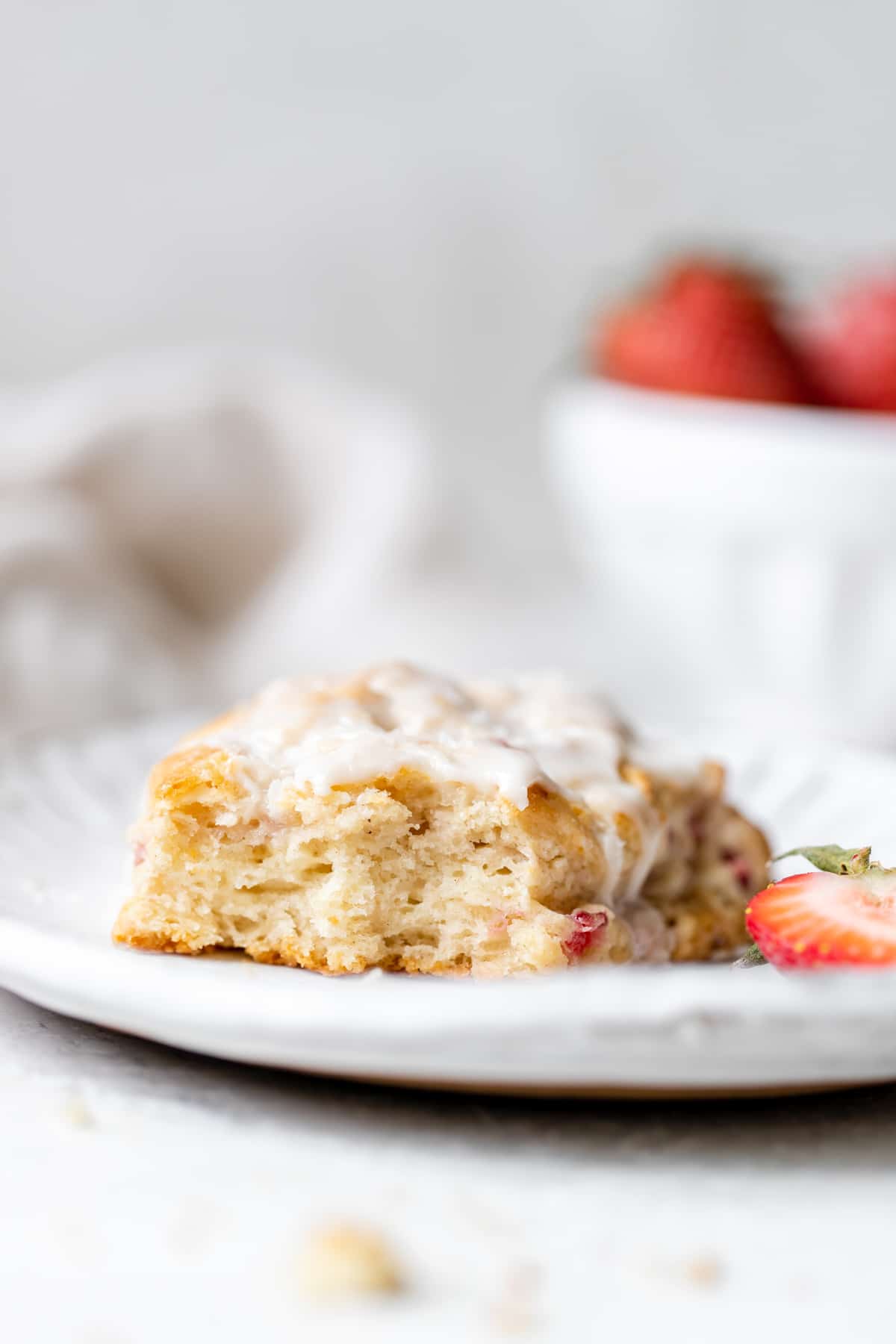 a scone on a white plate with a bite taken out of it 