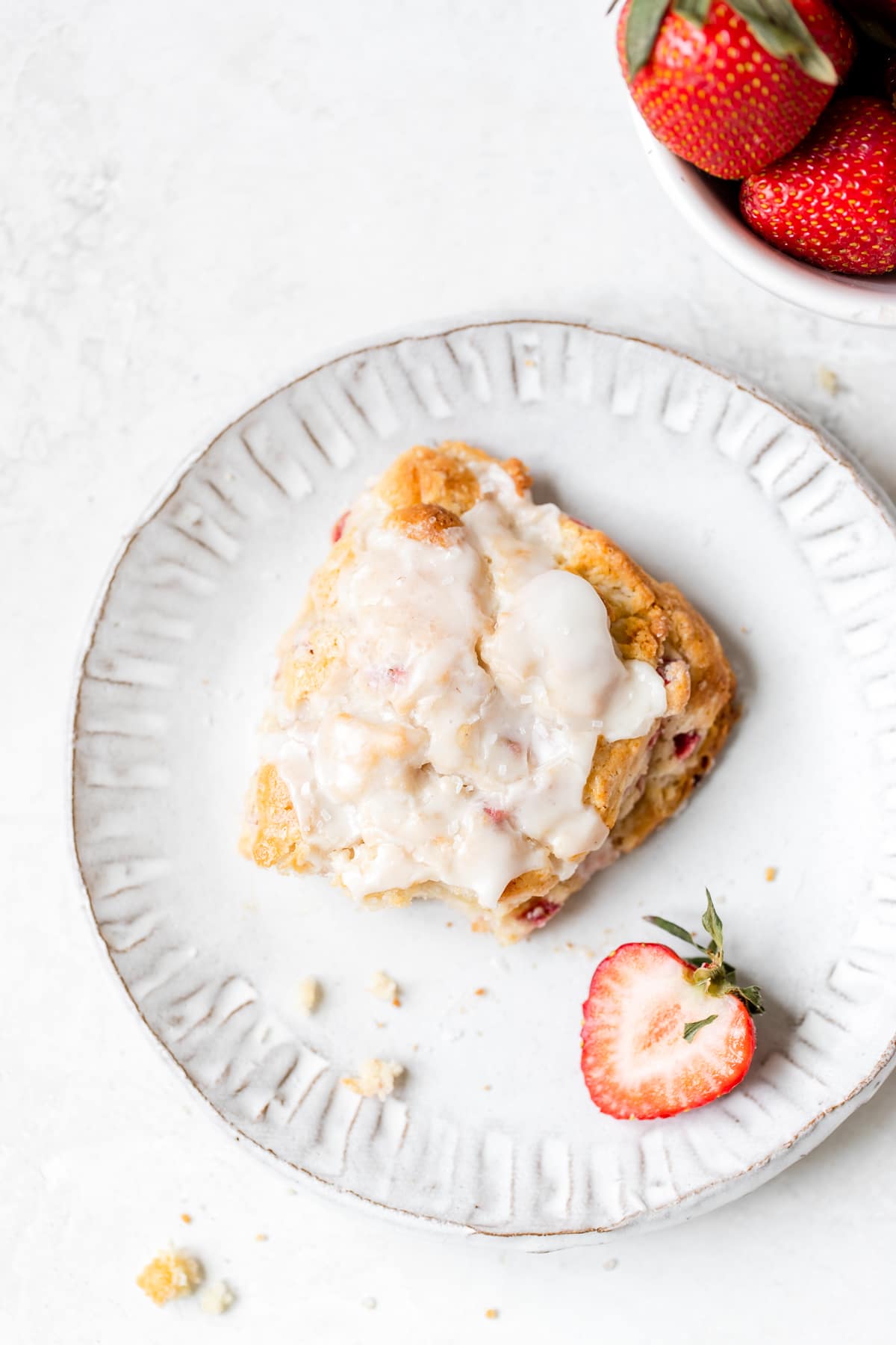 a scone on a white plate with a bite taken out of it 