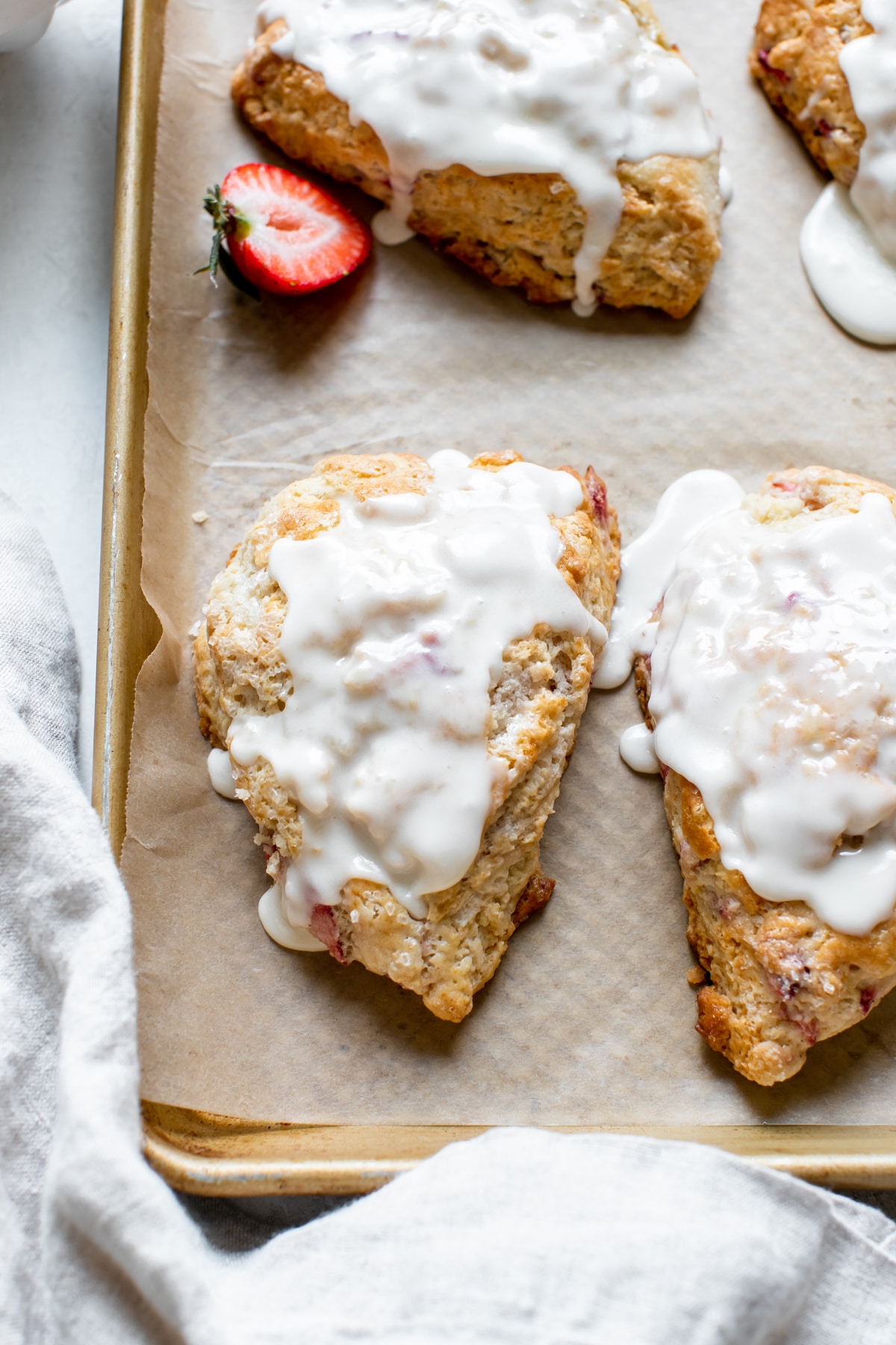 scones on a gold baking sheet with glaze on top