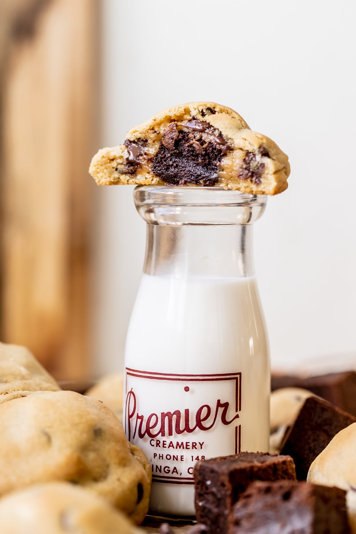 a cookie on top of a glass filled with milk. 