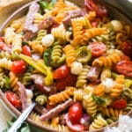 pasta in a bowl with sausage and tomatoes and cheese.