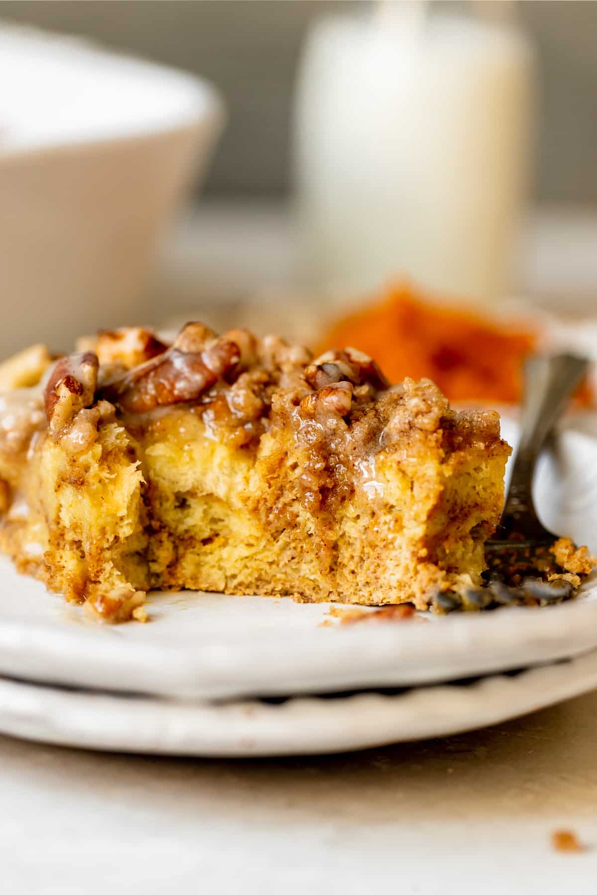 french toast made with pumpkin on a white plate topped with a brown sugar pecan streusel and maple glaze. 