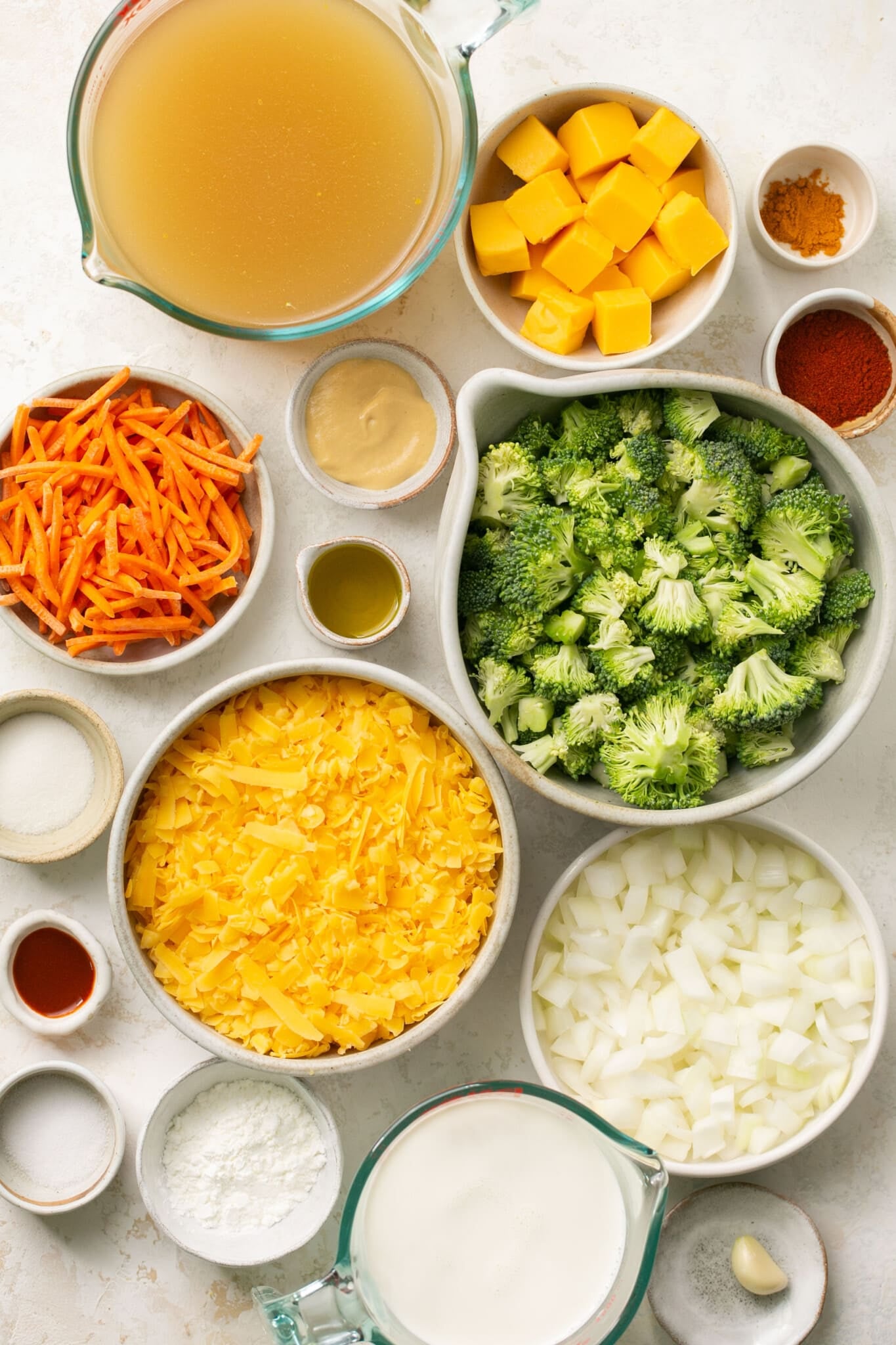 ingredients to make broccoli cheddar soup in white bowls. 