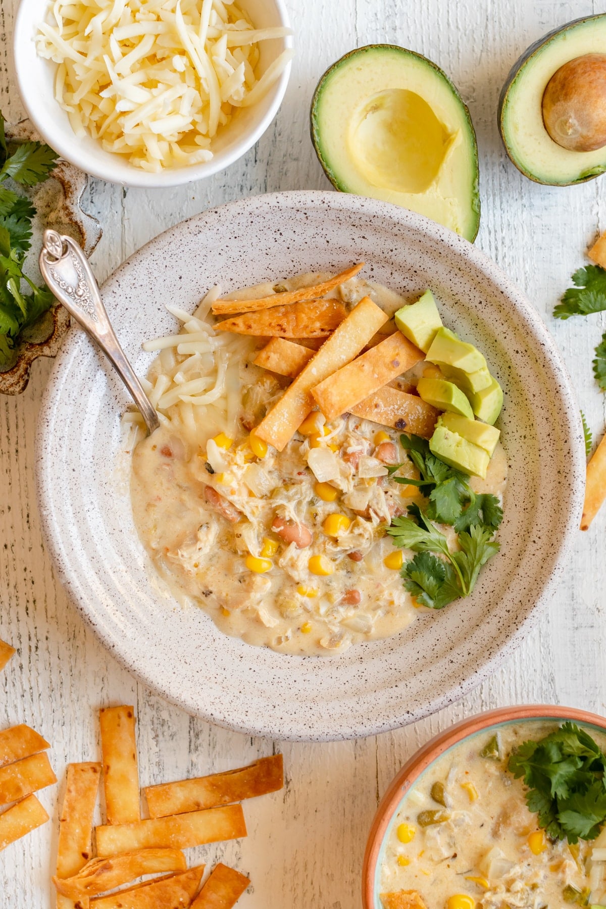 enchilada soup in a bowl garnished with cilantro, tortilla strips, avocado and Monterey Jack cheese. 