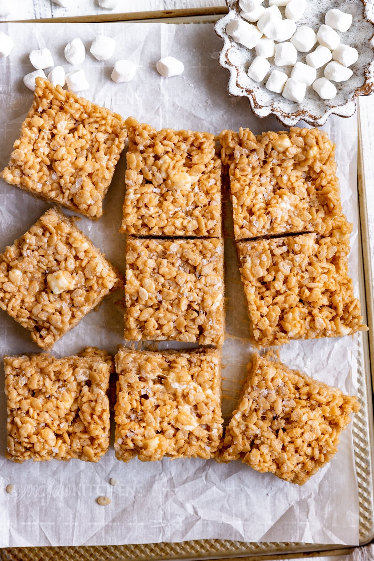 rice krispies cut into squares on parchment paper.