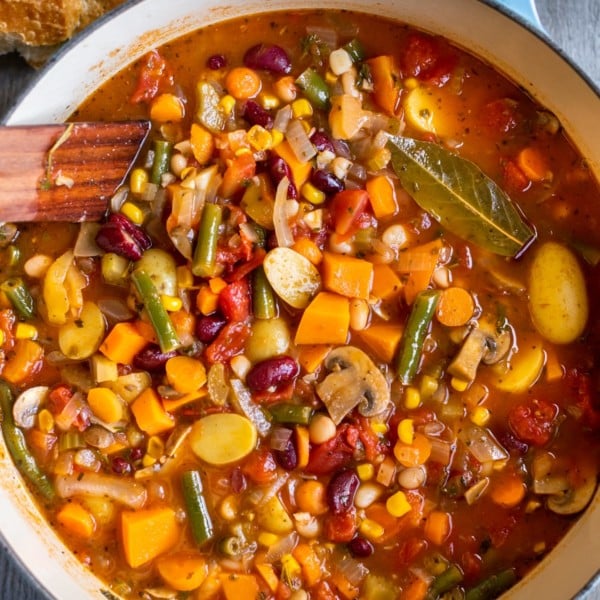 vegetable soup in a blue dutch oven with crusty bread on the side.
