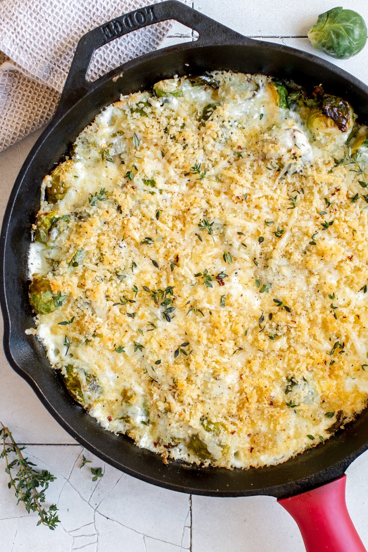 cast iron skilled with creamy brussels sprouts topped with toasted cheese