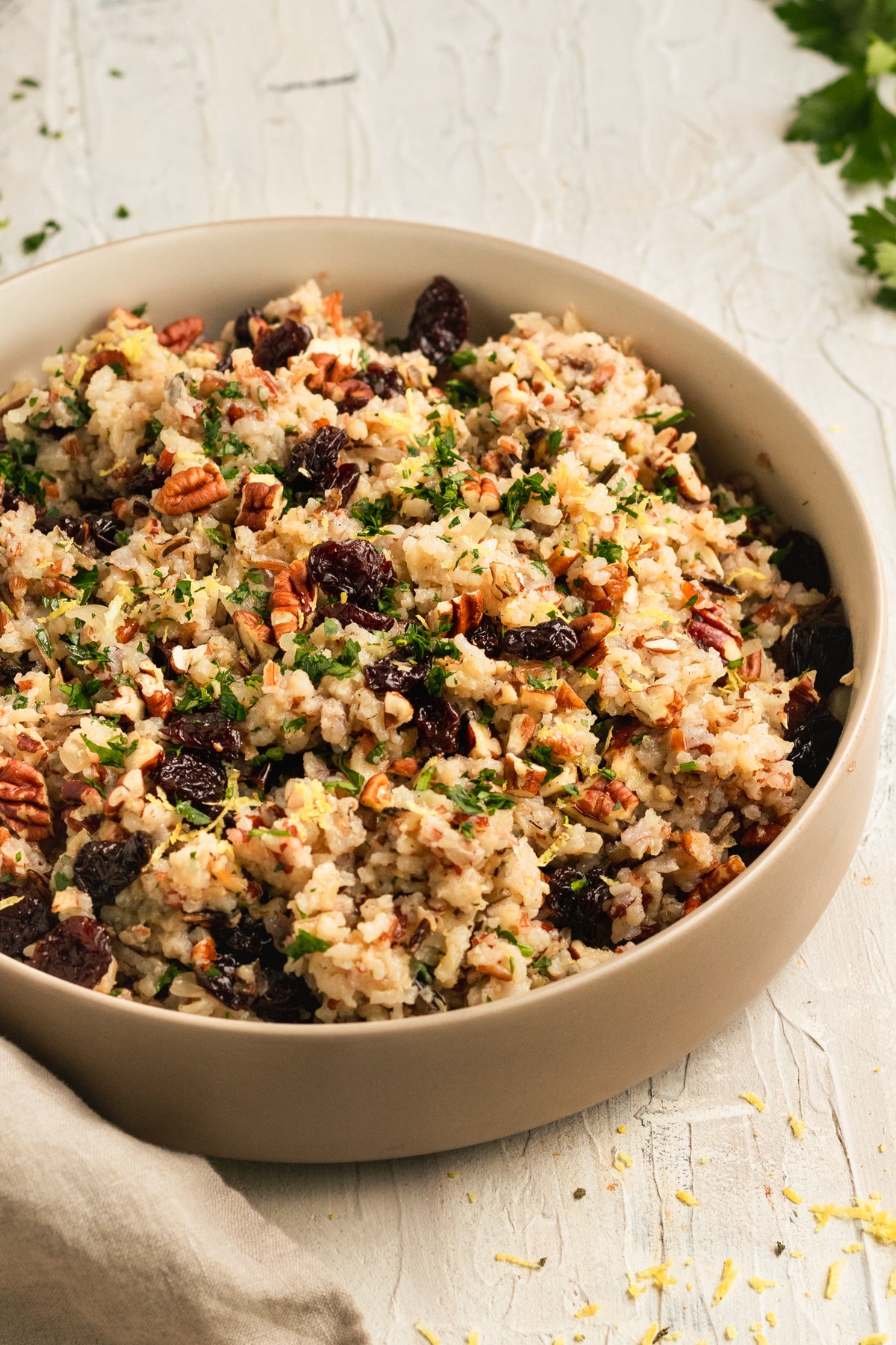 rice in a bowl garnished with dried cherries, lemon zest, and fresh parsley.