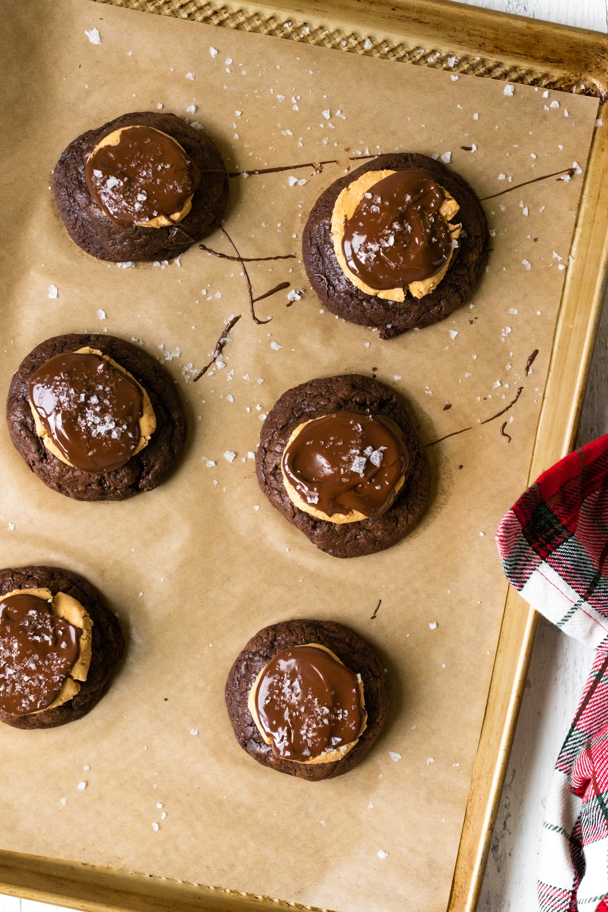 cookies on a baking sheet topped with peanut butter and chocolate 