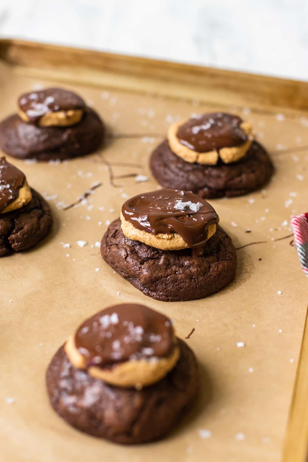 cookies on a baking sheet topped with peanut butter and chocolate.