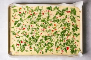 eggs and veggies on a sheet pan prior to baking