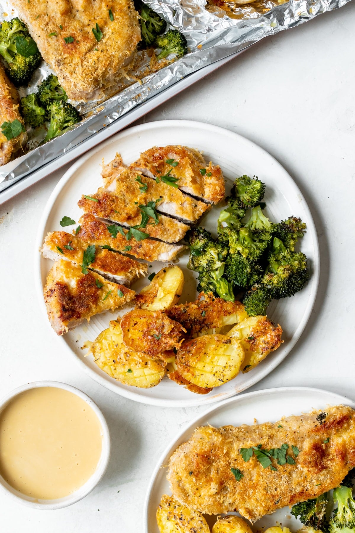 pork chop, broccoli and potatoes on a white plate. 