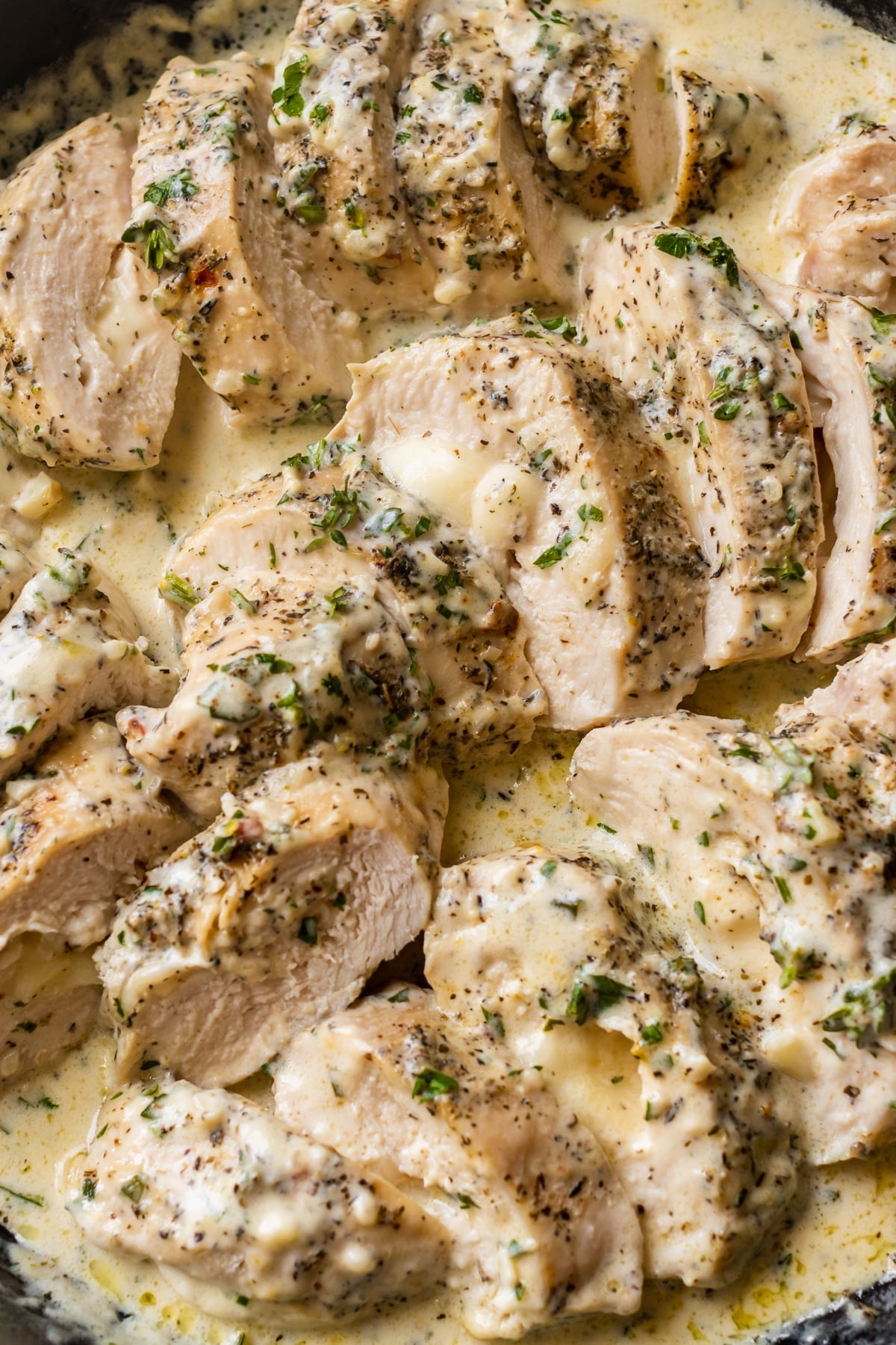 slices of chicken breast in a mozzarella cream sauce topped with herbs