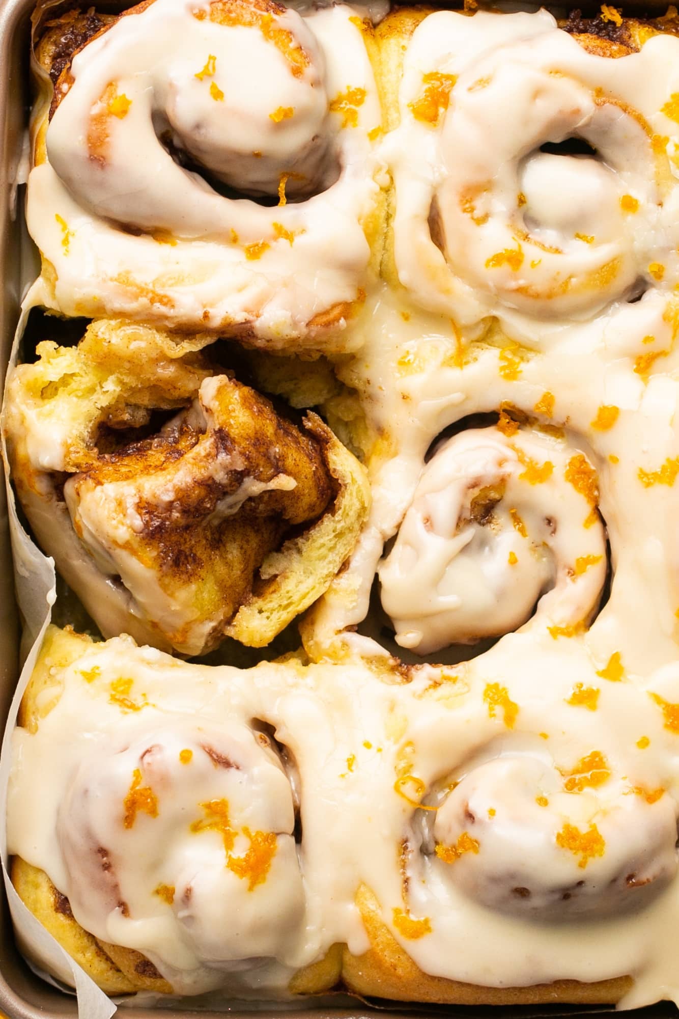 a close up image of orange cinnamon rolls.