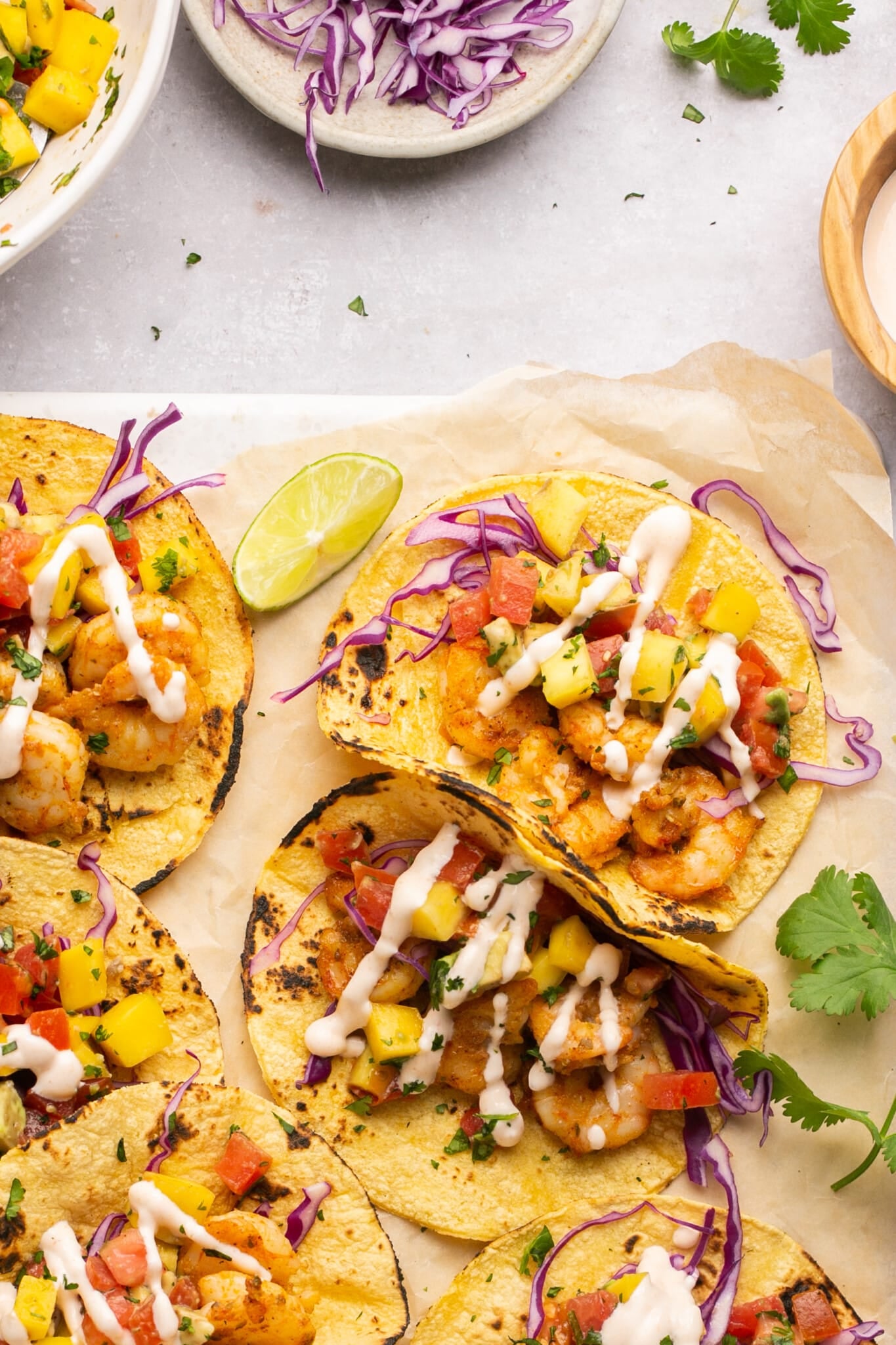 tacos on corn tortillas with taco sauce and purple cabbage on top.