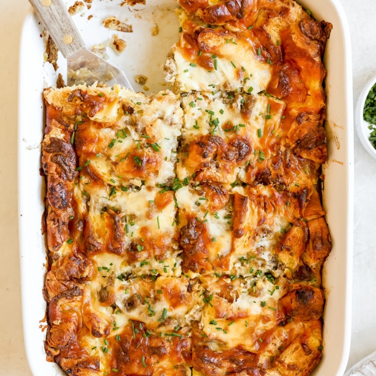 white casserole dish filled with cooked egg and sausage casserole topped with chopped chives