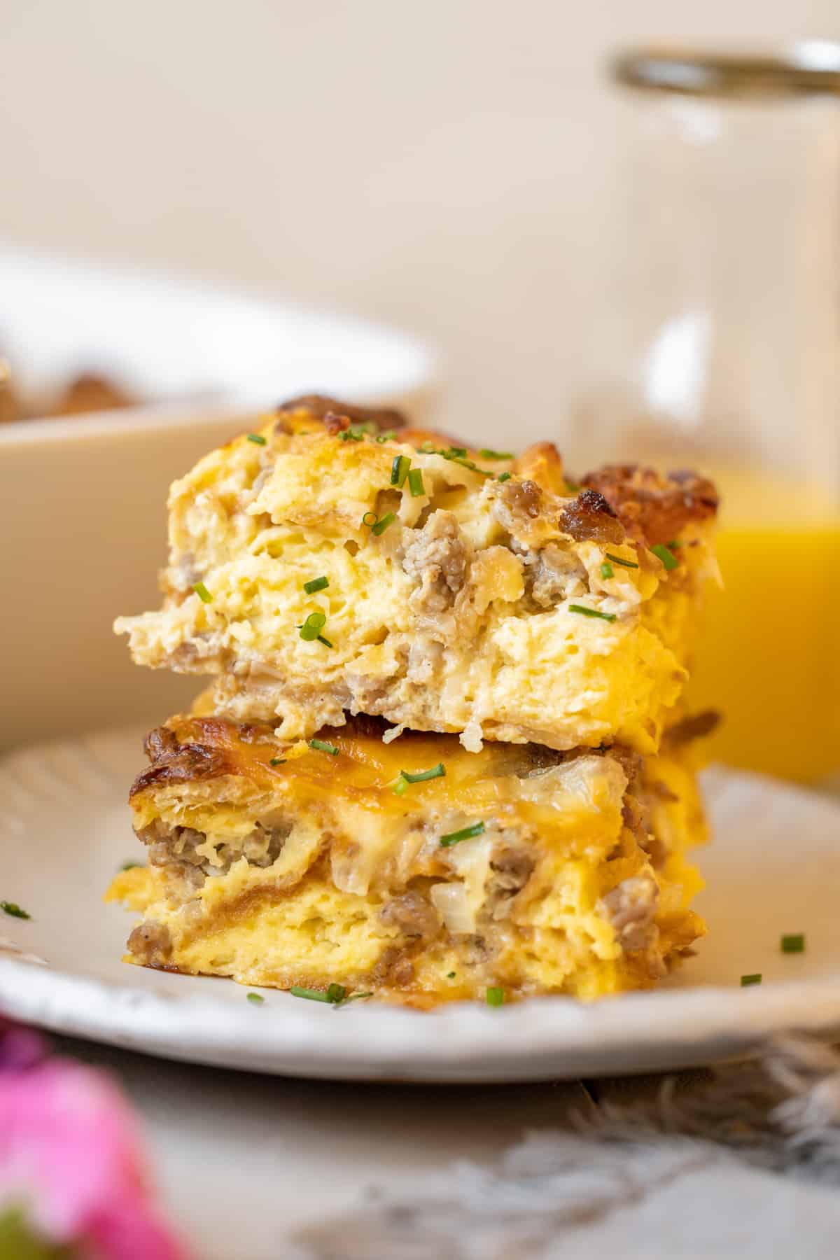 breakfast sausage casserole on a plate with chives on top. 