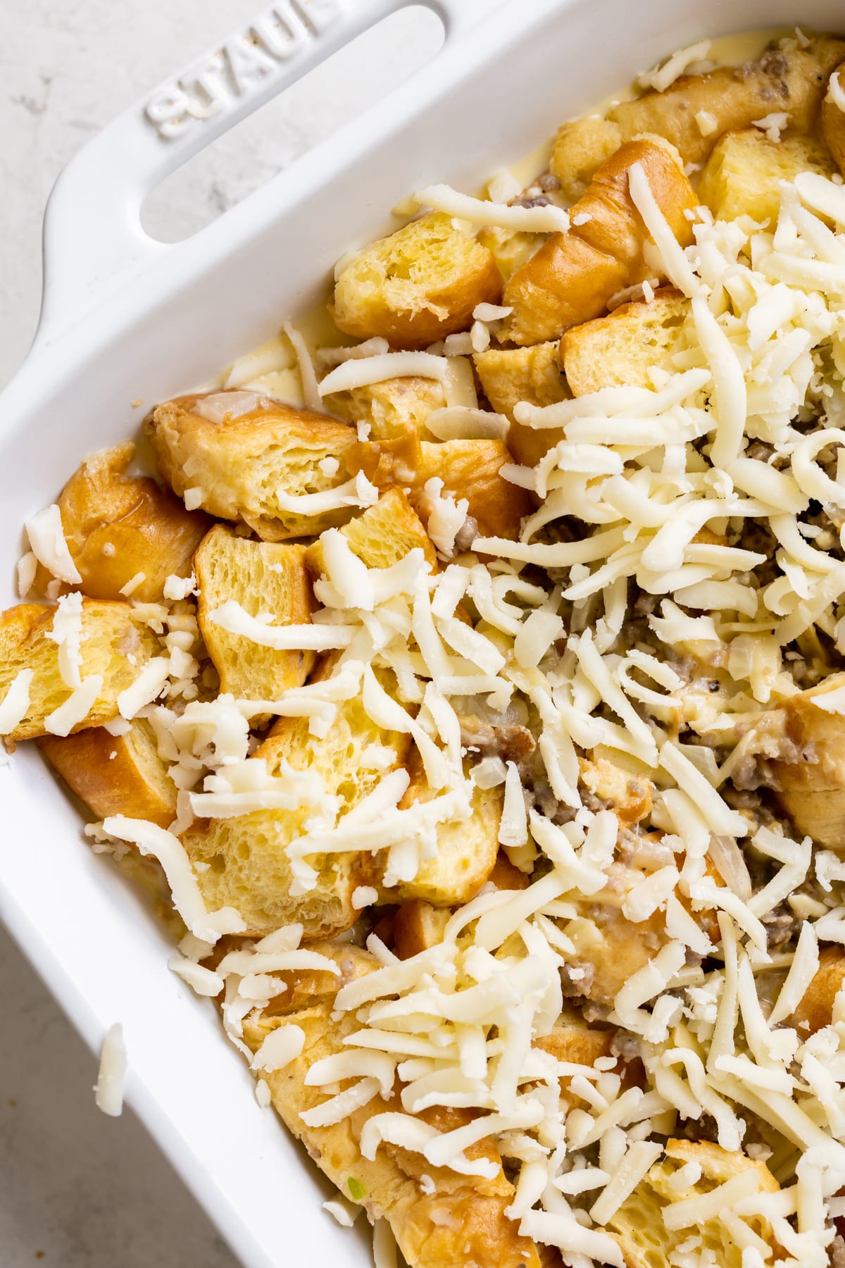 an up close image of a casserole with cheese on top. 