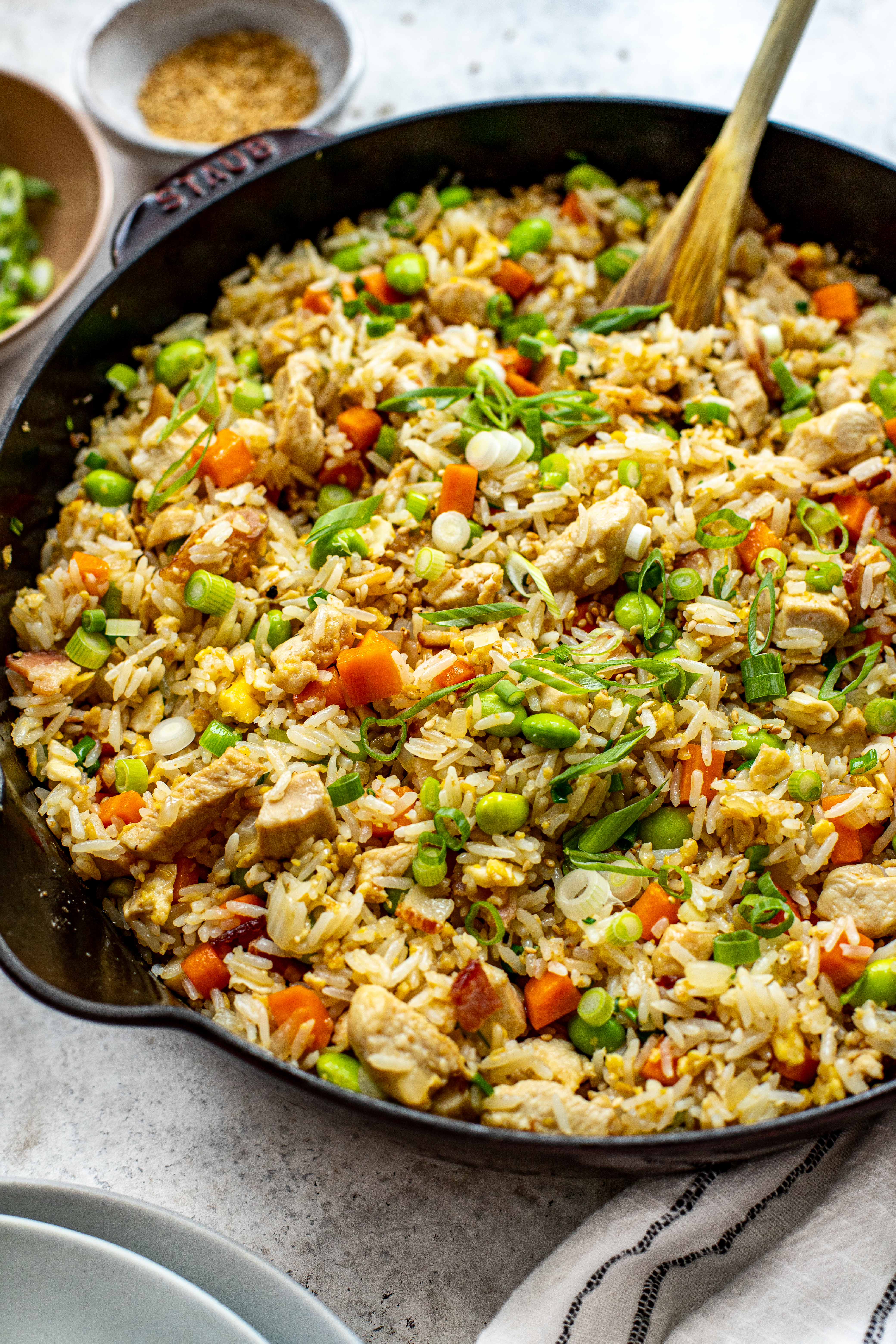fried rice in a cast iron pan with green onions and edamame. 