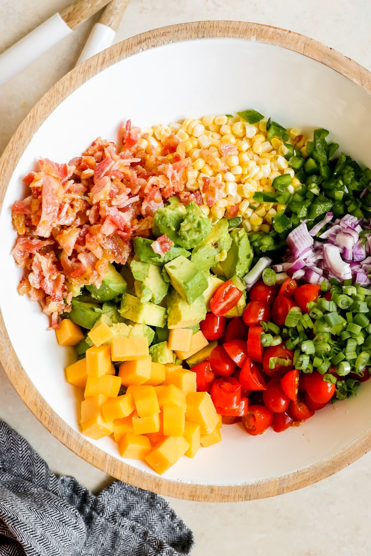 ingredients for a corn salad in a large white bowl.