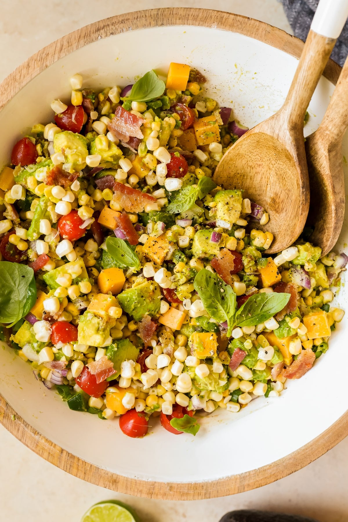 salad with corn and avocado in a large white bowl.