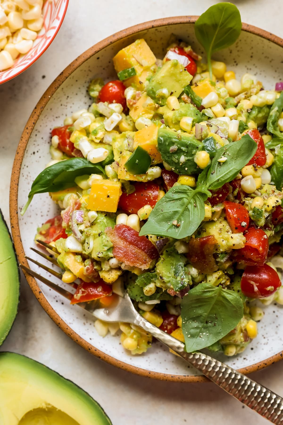 corn salad in a white speckled bowl.