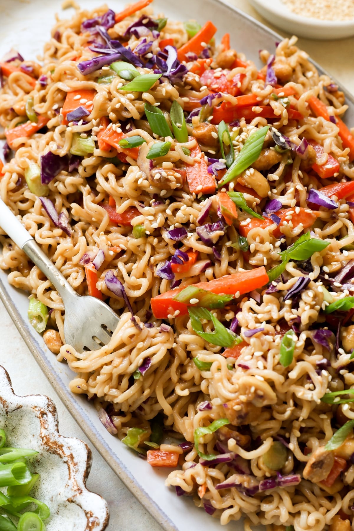cold noodle salad on a plate garnished with green onions.