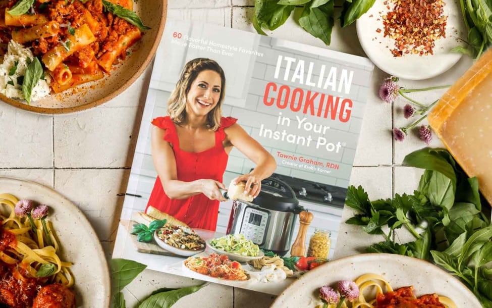Cookbook surrounded by fresh ingredients.