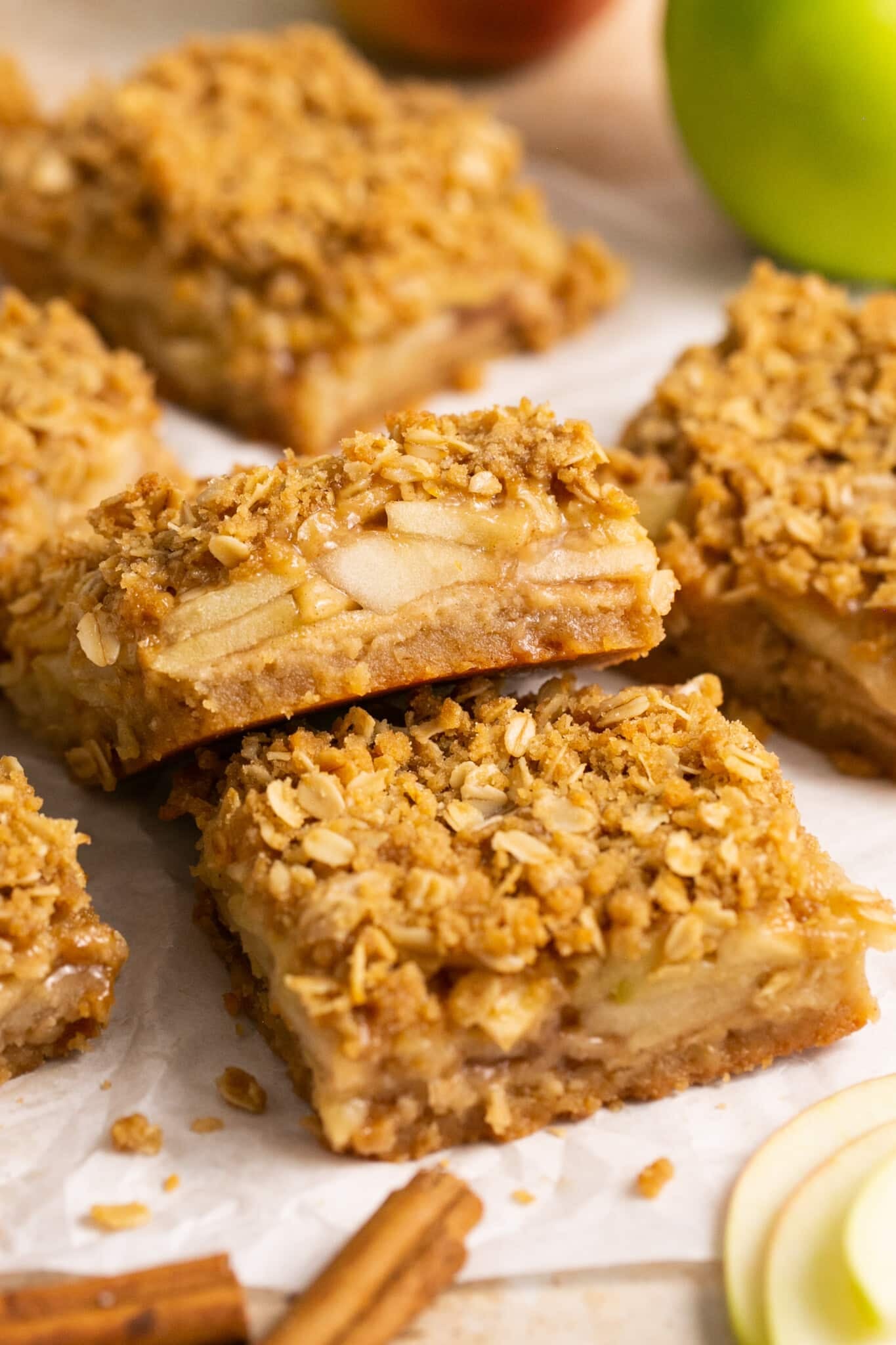 An apple pie bar on white parchment paper. 