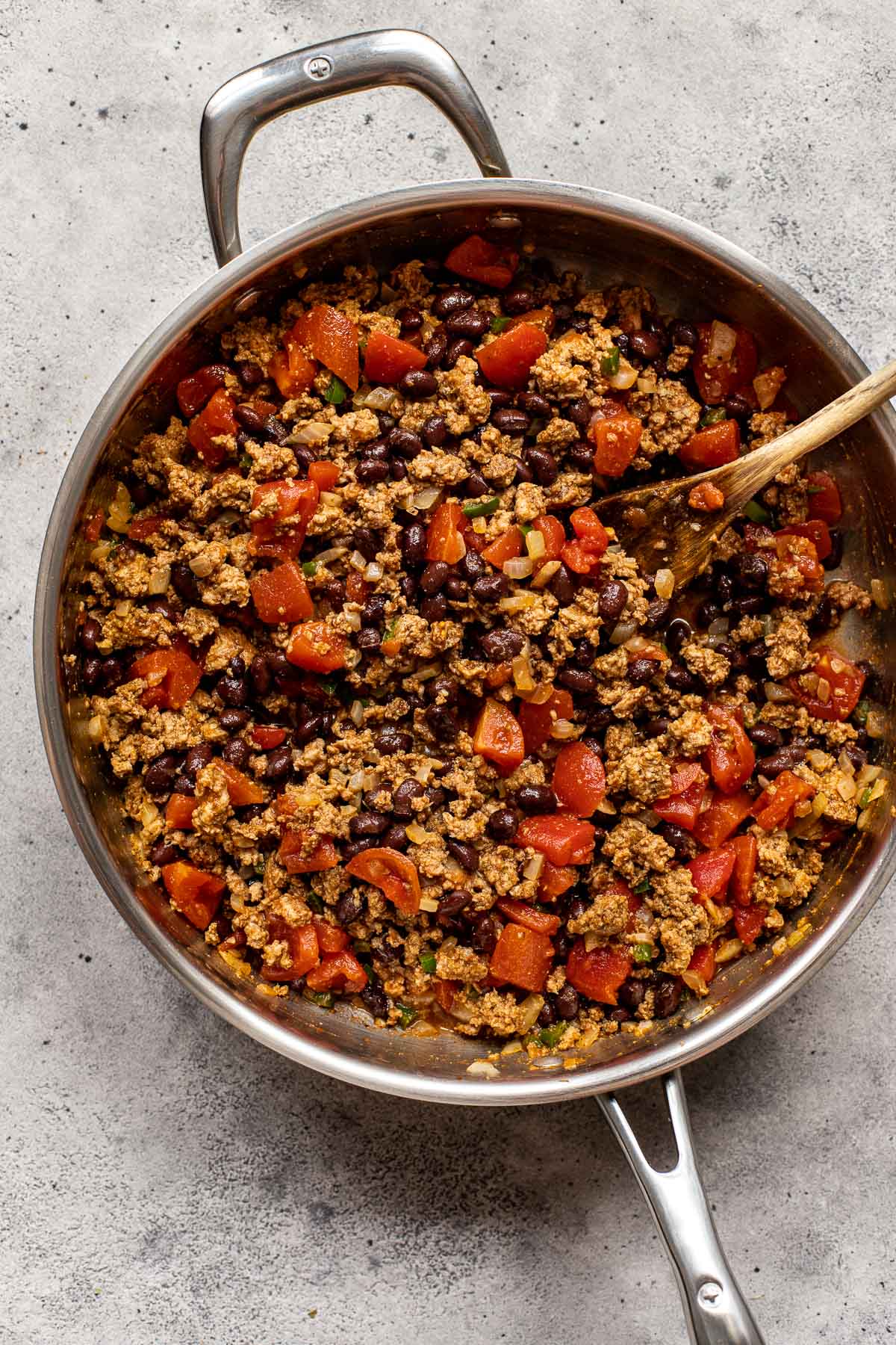 ground turkey in a skillet with diced tomatoes and black beans. 