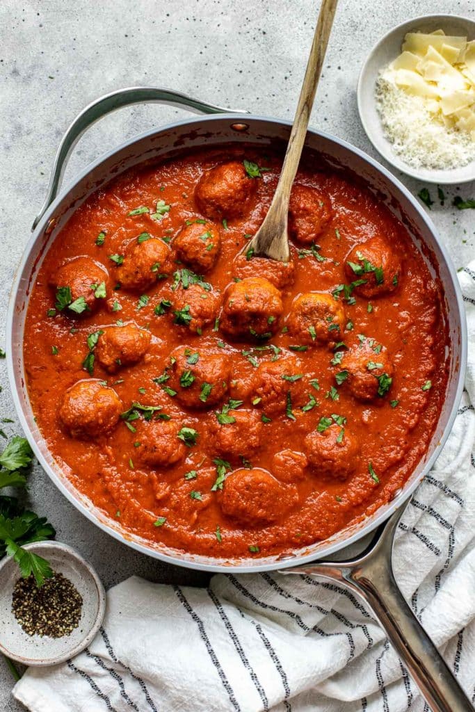 Meatballs in a pan garnished with parsley. 