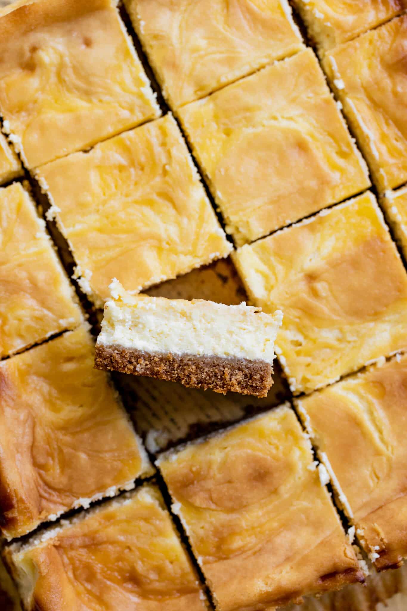 cheesecake cut into bars on parchment paper.