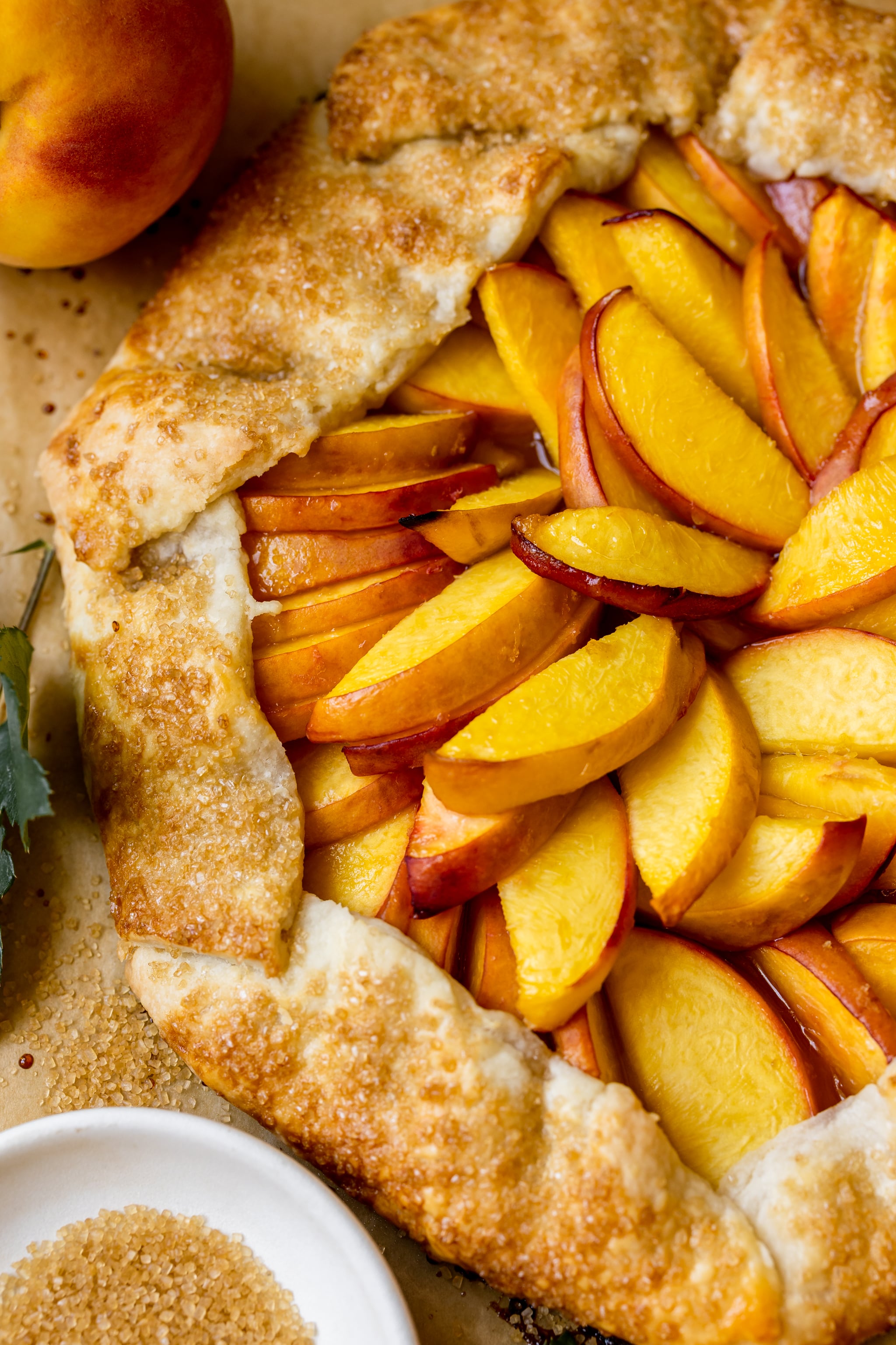 a freshly baked peach galette on parchment paper. 