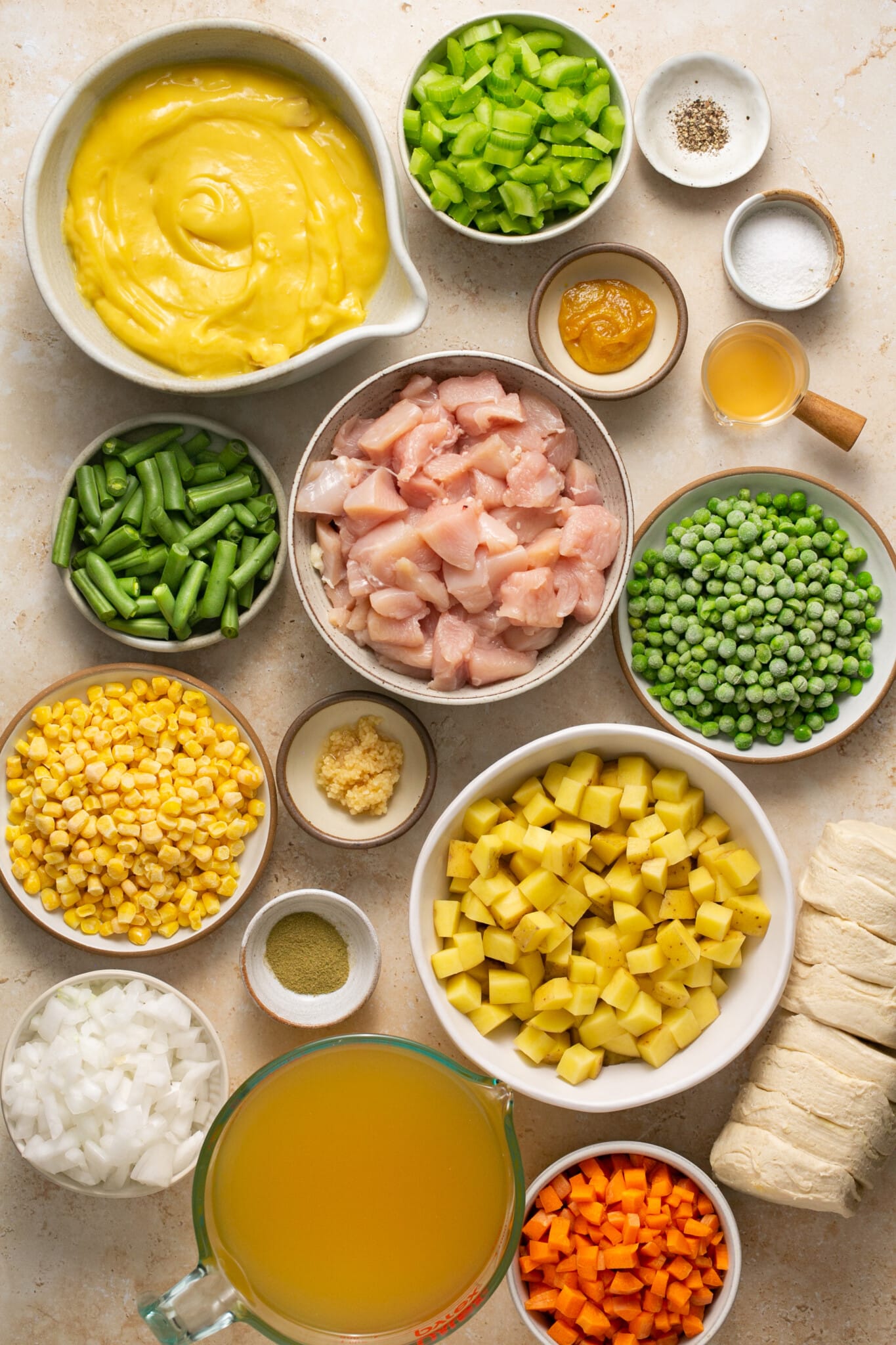 ingredients in white bowls needed to make chicken pot pie soup.