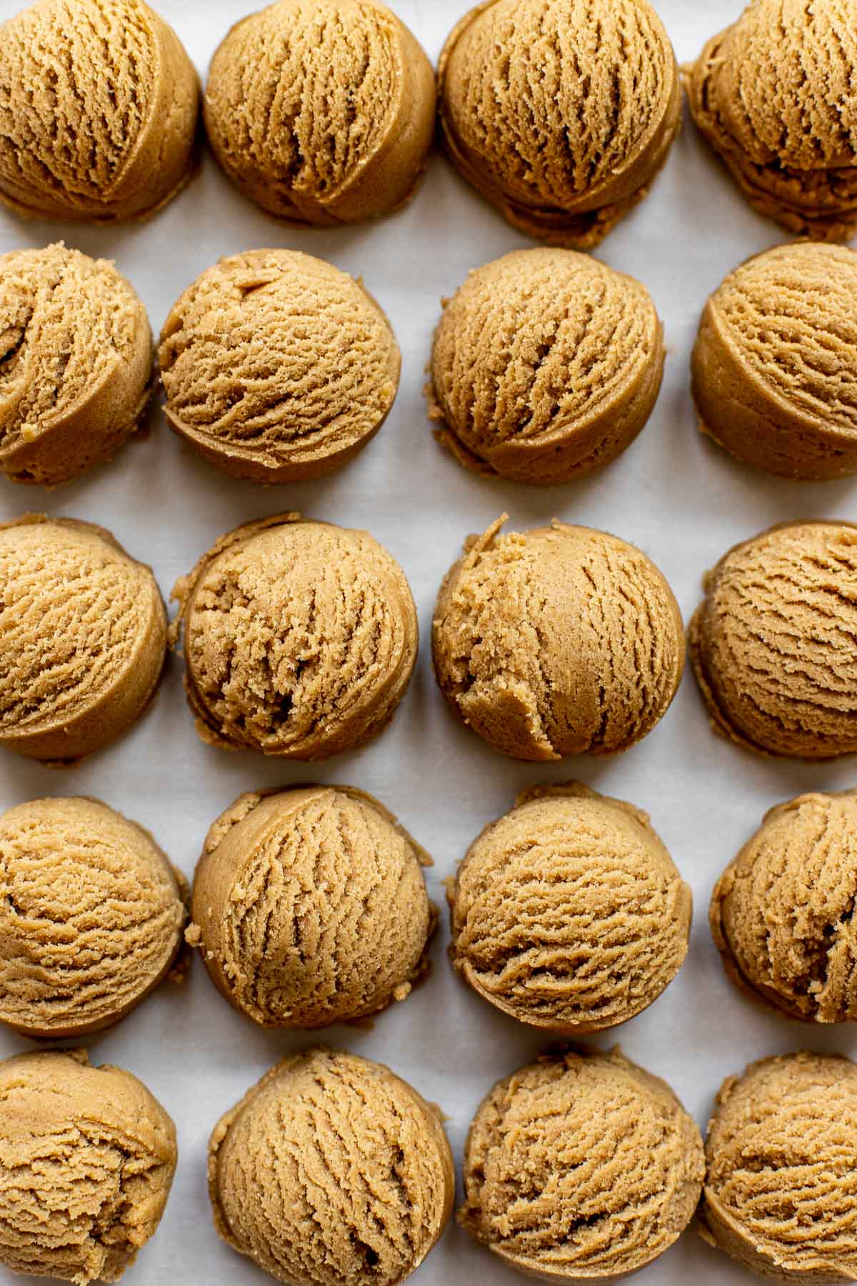scooped cookie dough on parchment paper.