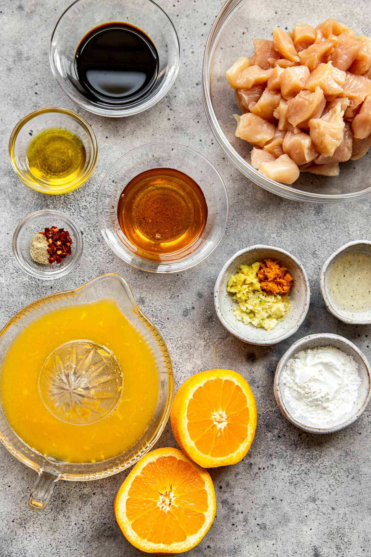 ingredients to make orange chicken in small glass dishes. 