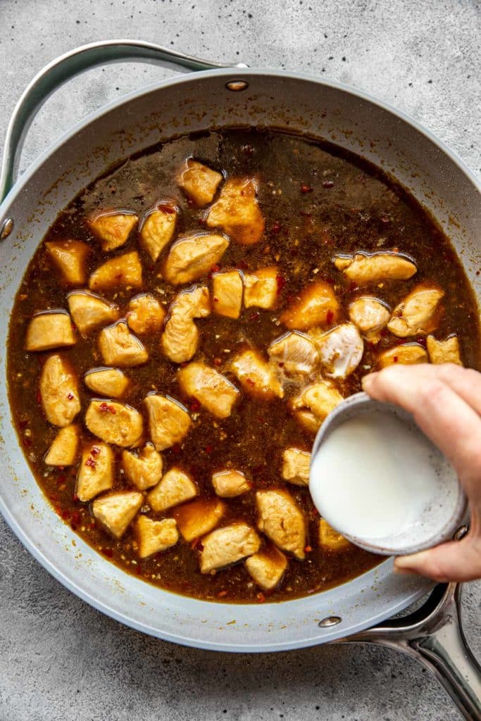 thickening orange chicken sauce with cornstarch in a skillet. 