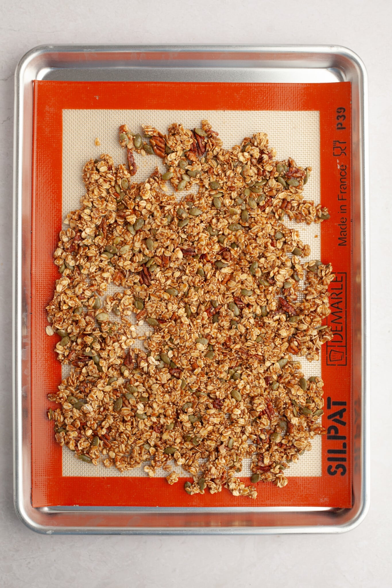 granola on a sheet pan on a silpat mat. 