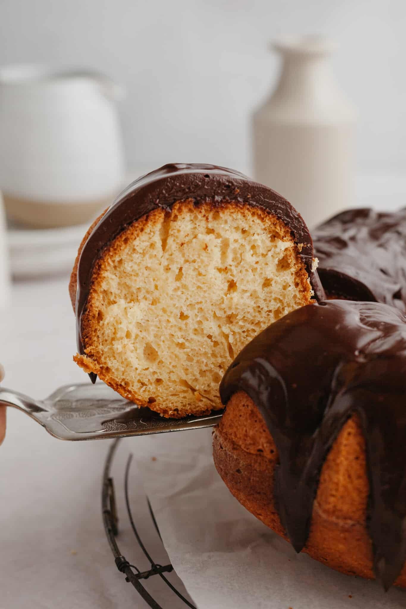 a slice of rum cake topped with chocolate ganache. 
