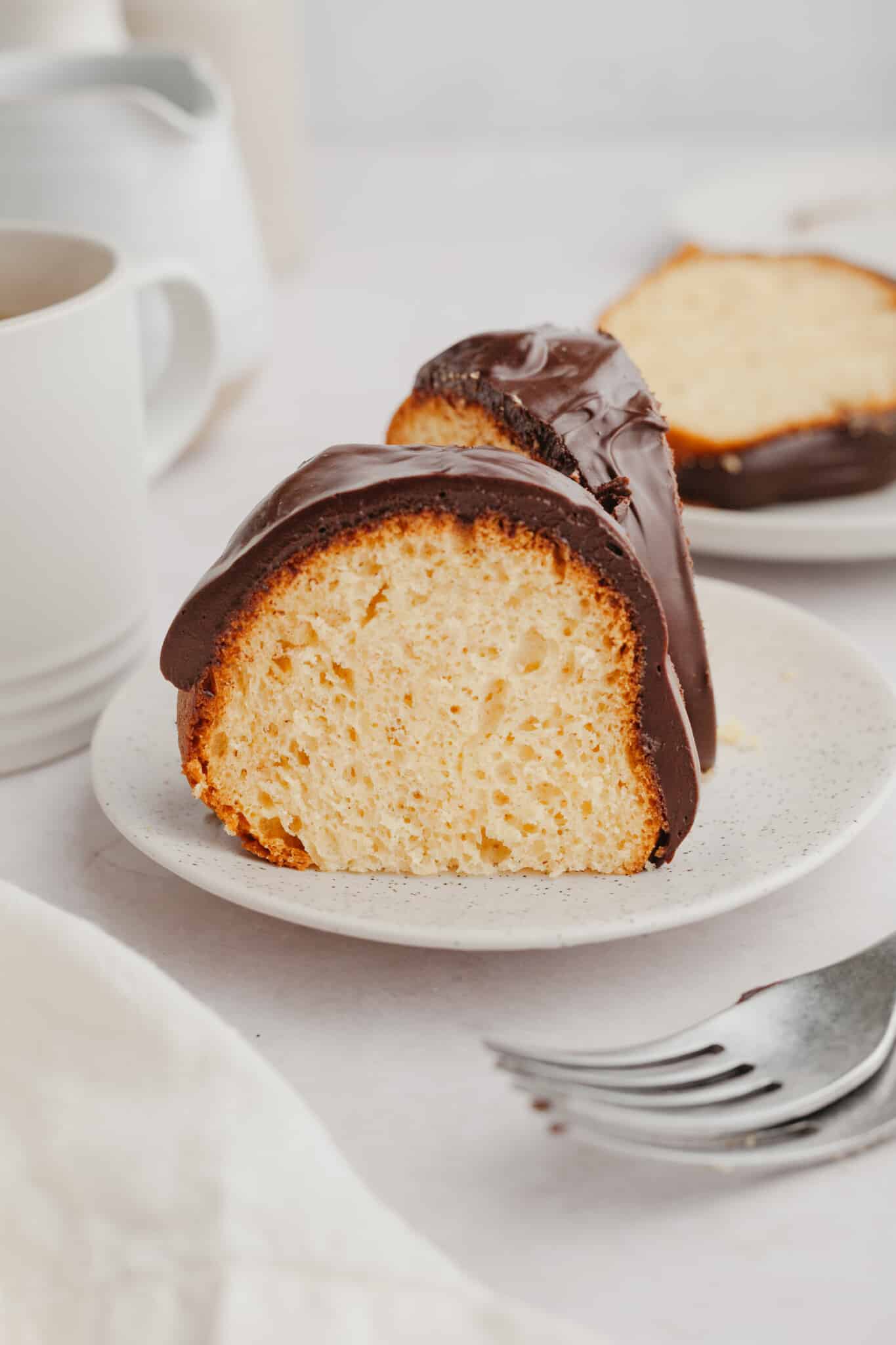 cake on a plate with chocolate ganache on top.
