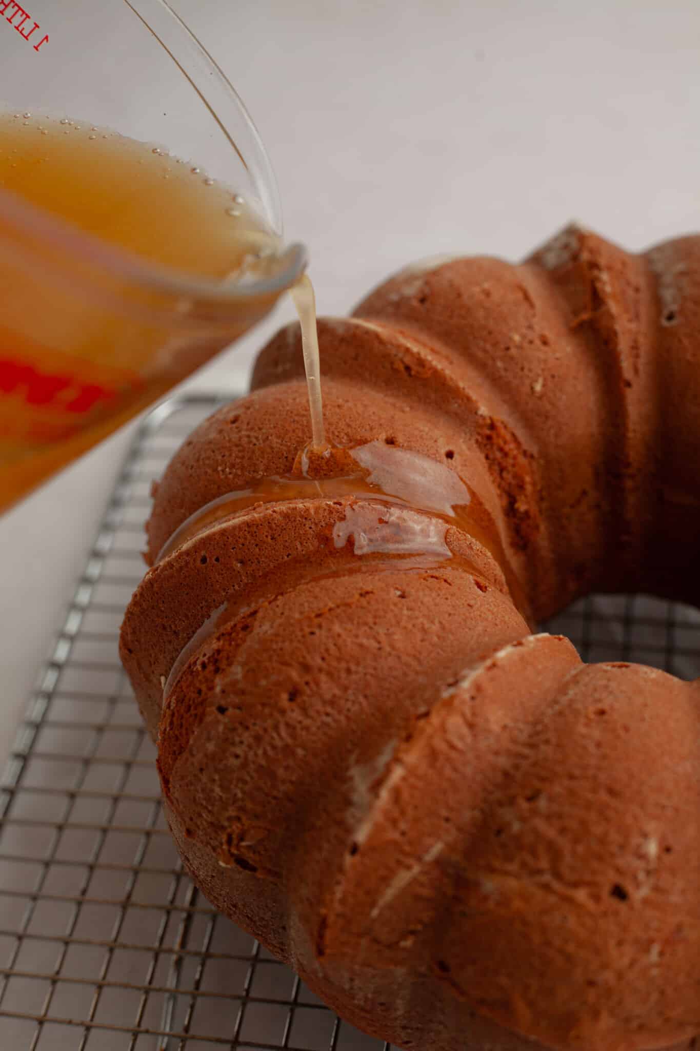 glaze being poured onto rum cake. 