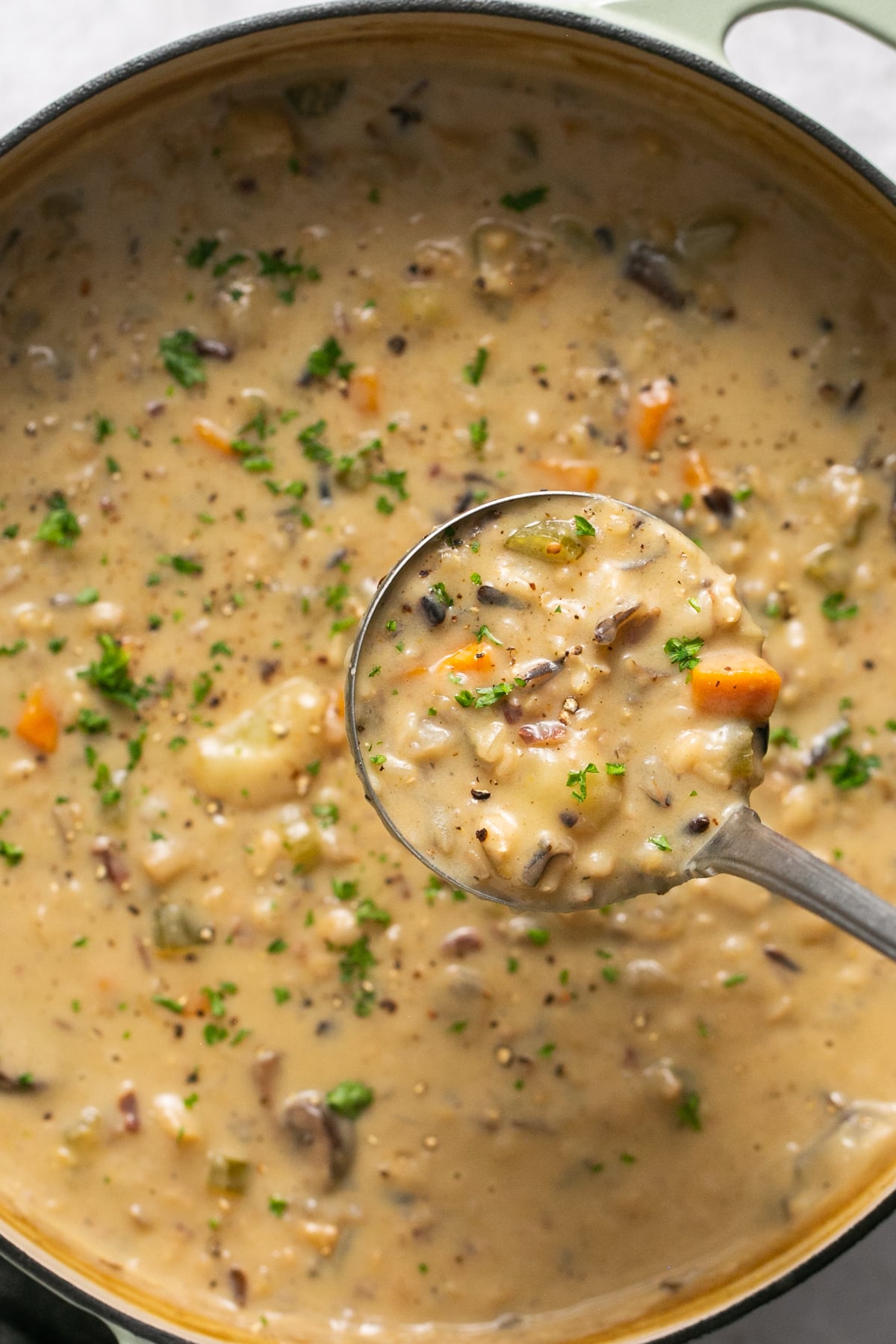 soup in a dutch oven with a ladle scooping some out.
