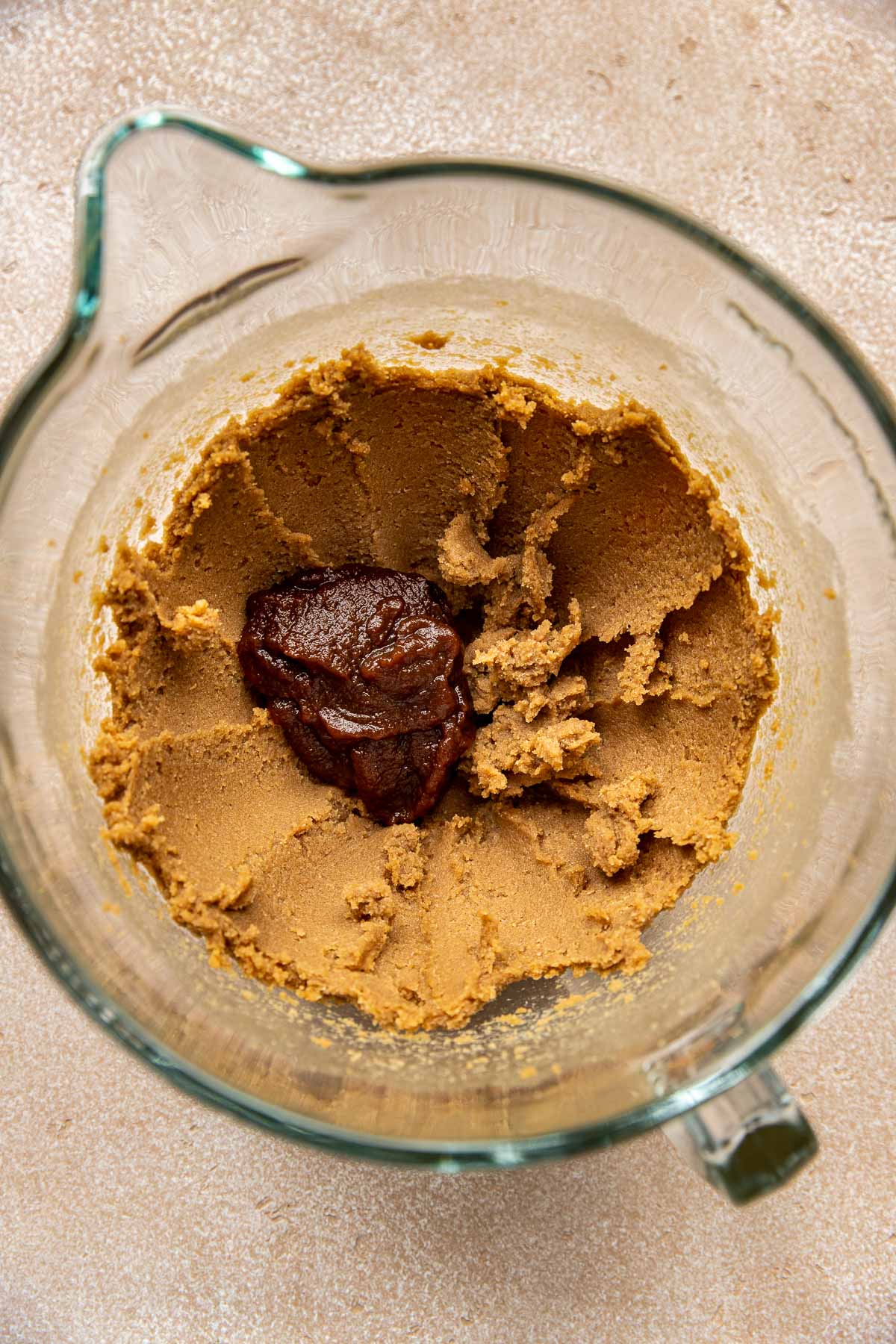 cookie dough in a glass mixing bowl with apple butter.