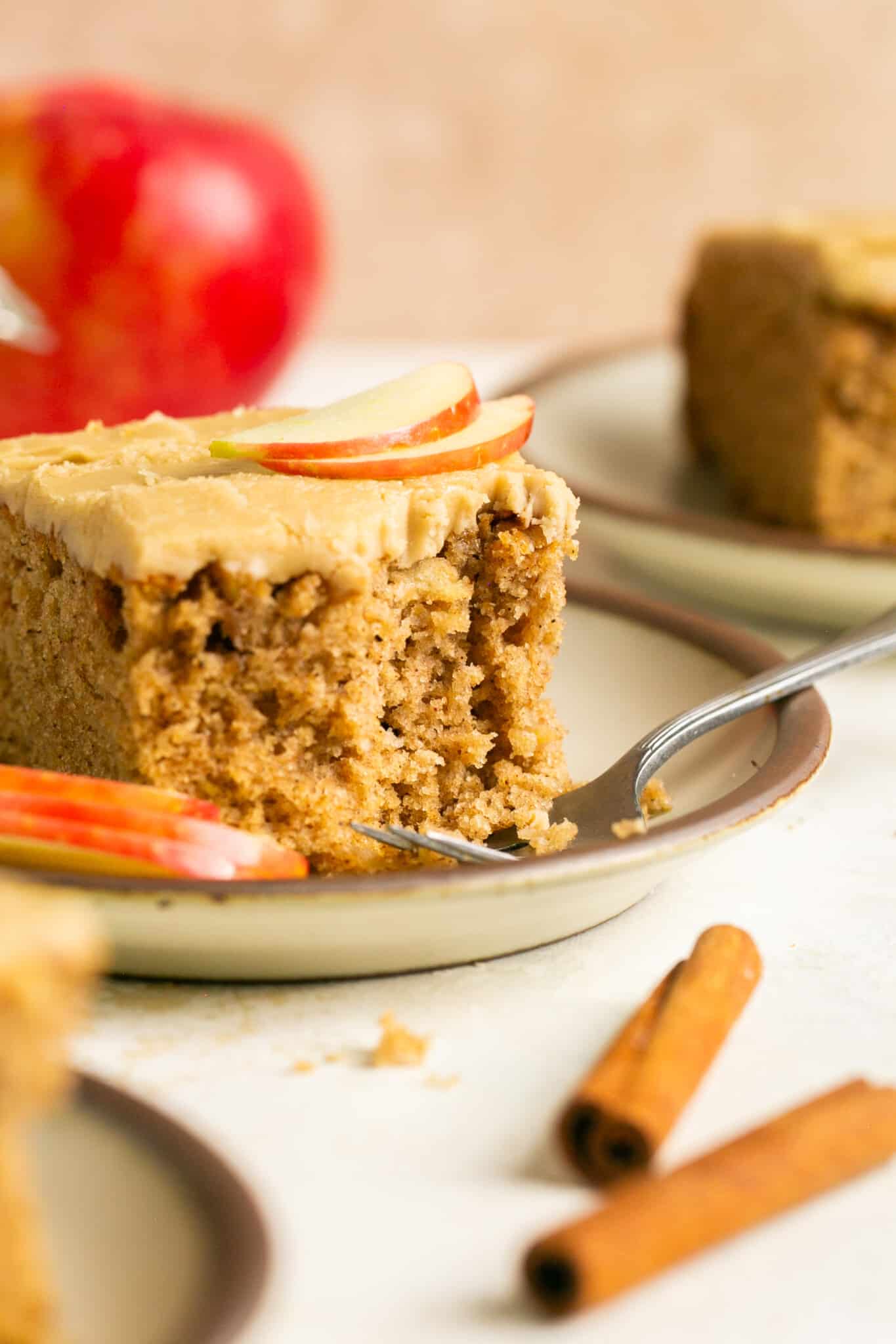 apple cake on a plate with a bite taken from it. 