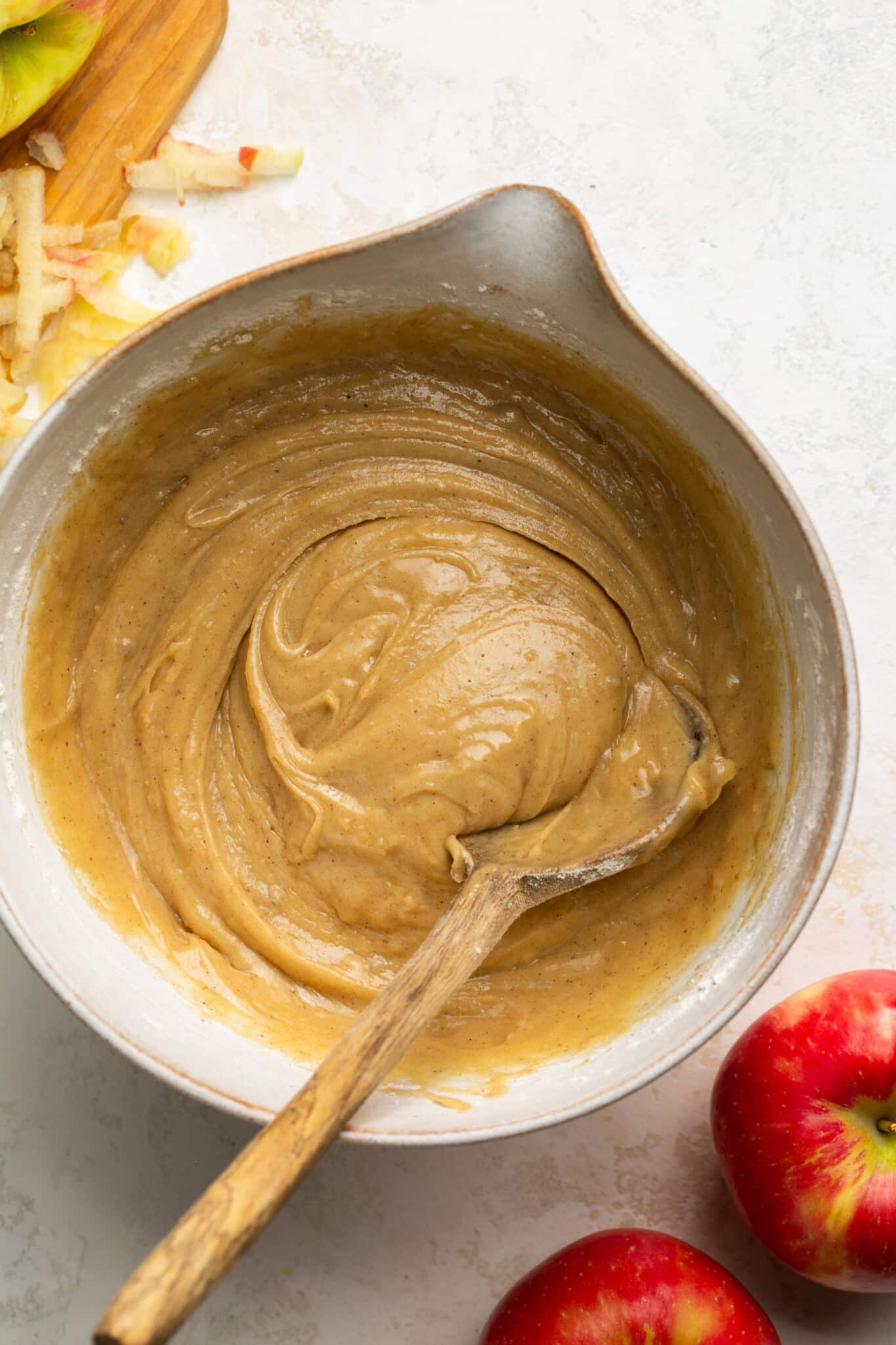 cake batter in a mixing bowl with a wooden spoon. 