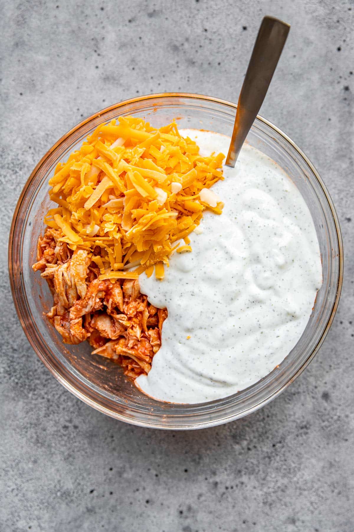 chicken, cheese and sauce in a glass bowl. 