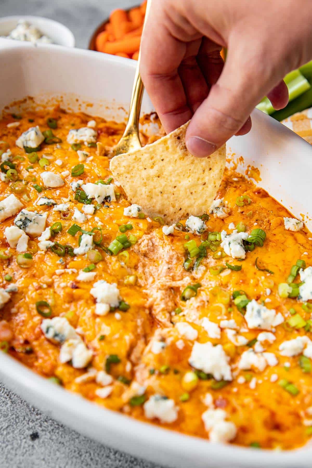 a chip dunking into a buffalo chicken dip. 