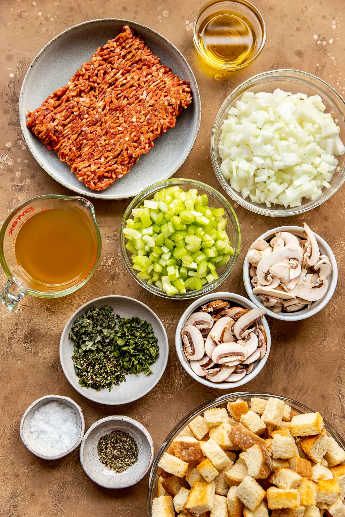 ingredients in glass bowls needed to make sausage stuffing. 