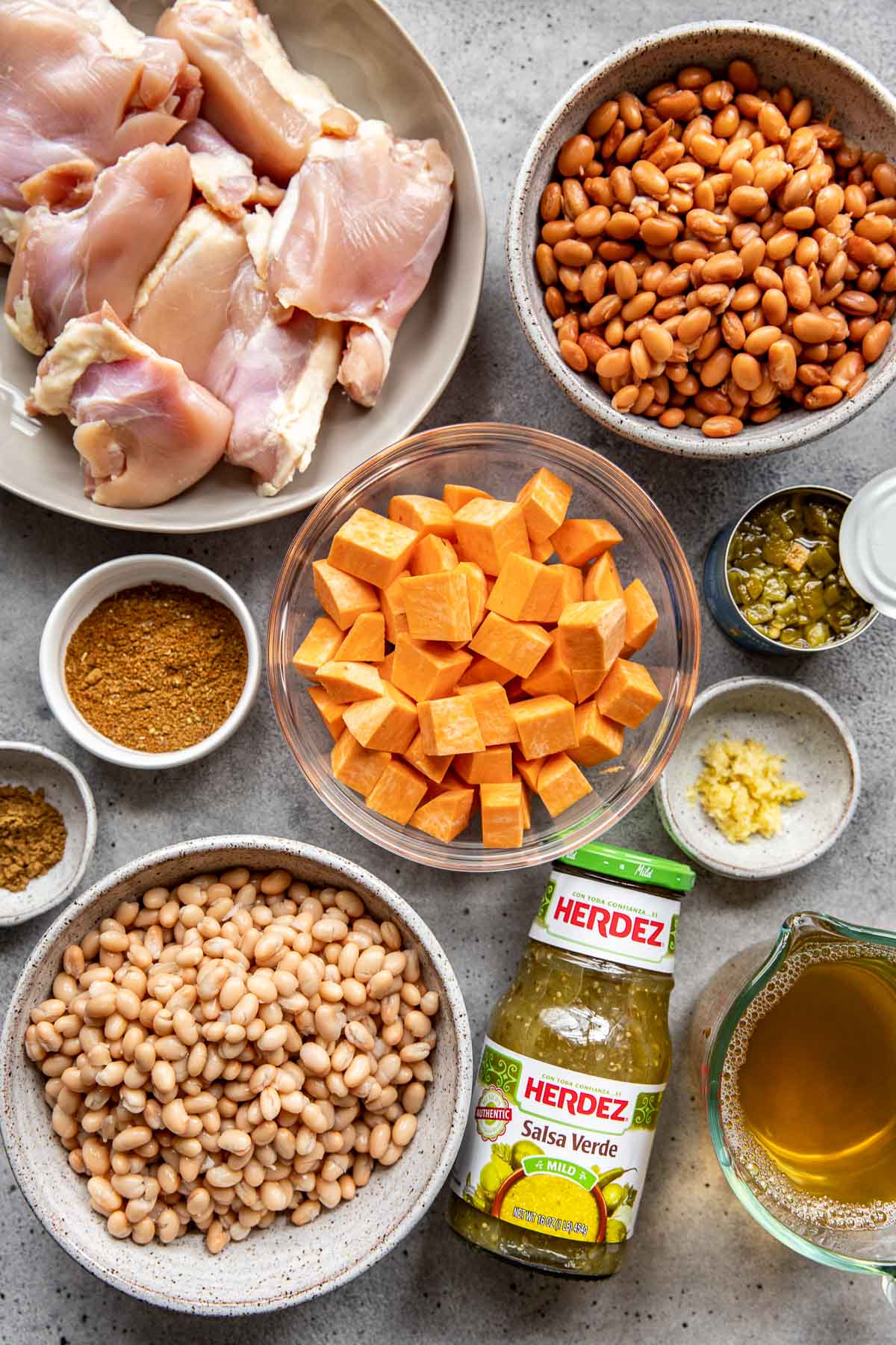 ingredients in small glass bowls needed to make a slow cooker green chicken chili soup. 