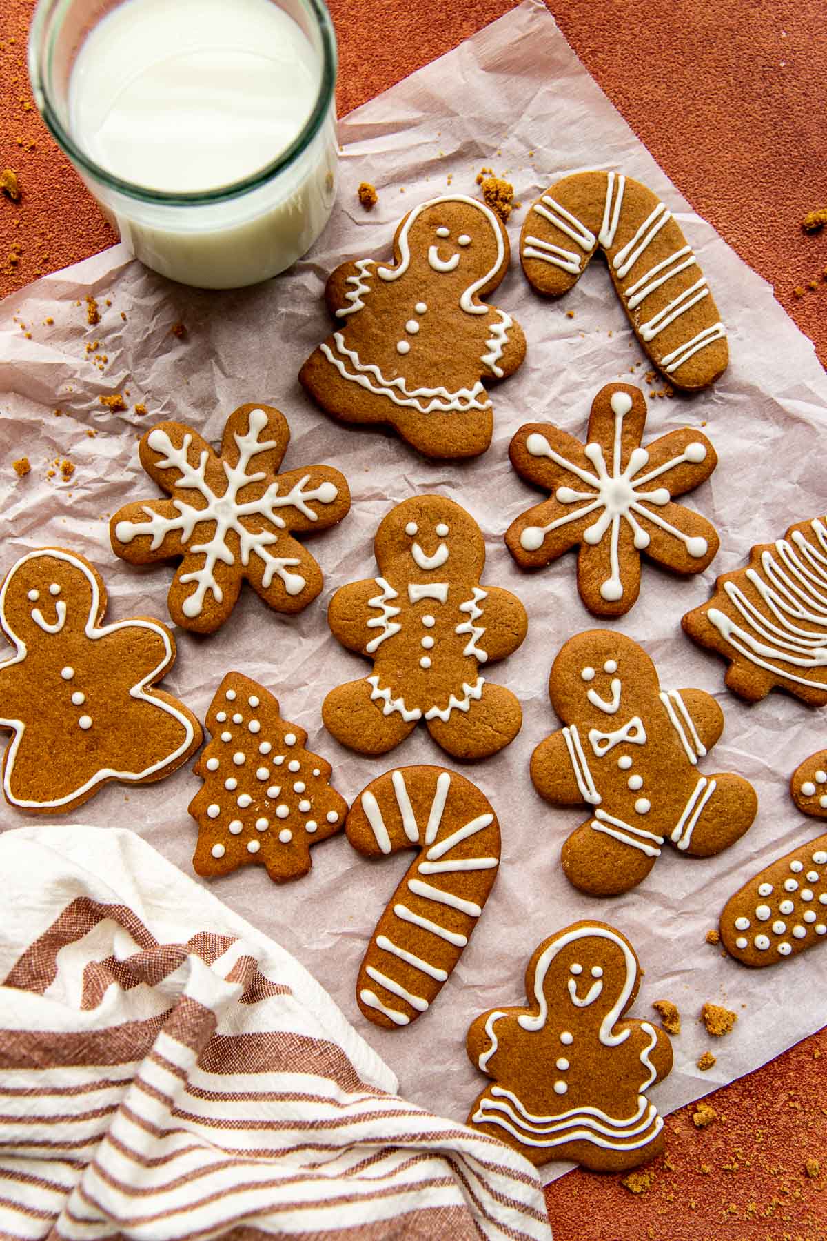 gingerbread man cookies on a piece of white parchment paper decorated with icing. 